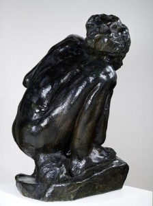 Black and white - newspaper print image of Rodin's bronze cast of crouching lady.