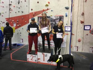 A photograph of the winners in the female VI category, I am stood on the 3rd block, which is not clear as Fizz my guide dog is stood directly in front of me.