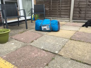 Image shows tent bag with tent inside sat out in the garden on patio.