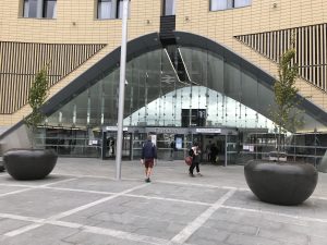 Photograph of the front exterior glass of Dundee relailway station, with it’s large archway and inside/outside marching paving.