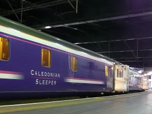 Photograph is of the side of The Caladonian Sleeper train carriage from the platform