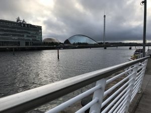 Photograph is taken beside the river Clyde railing, showing across the river with BBC Scotland on the left, with The Glasgow science centre dome shaped building along with The Glasgow tower on the right of the image, The imax cinema can be partly seen in between the bbc building and the science centre