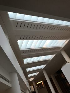 Photograph shows the stripped skylights that run parallel to each other in a triangular flat roof of The British Library